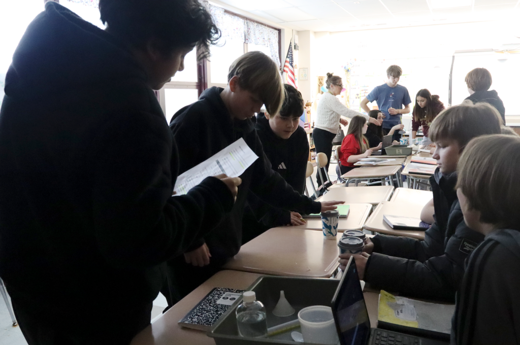 students reading science experiment
