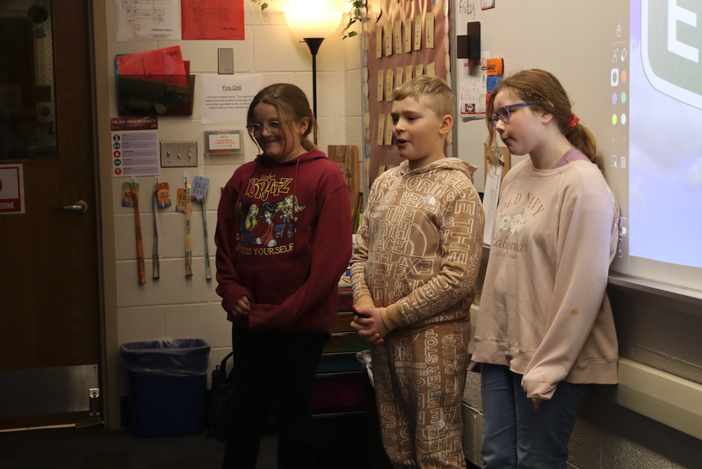 two girls and boy presenting