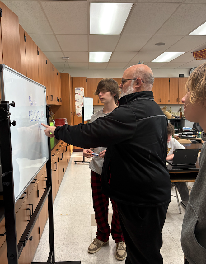 teacher showing students something on the white board