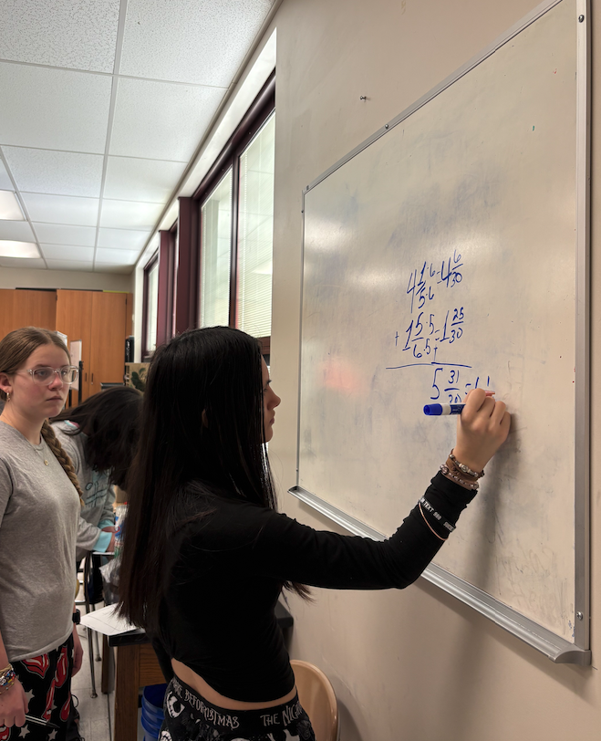 young woman writing on the white board