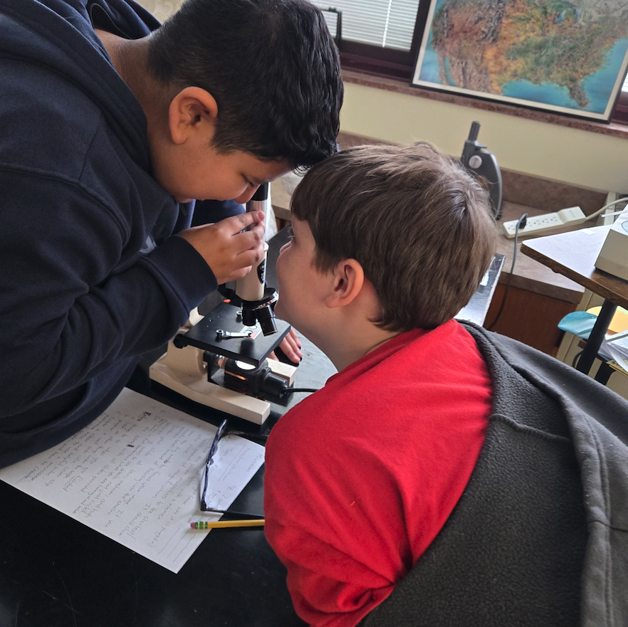 two. boys around a microscope