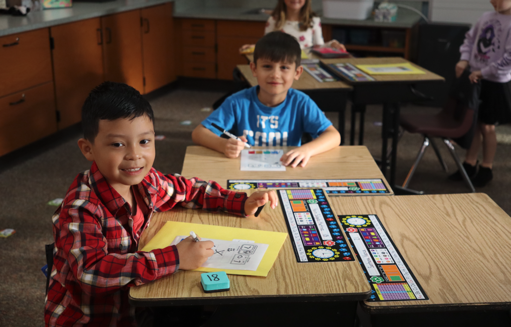 two little boys sitting at their desk writing