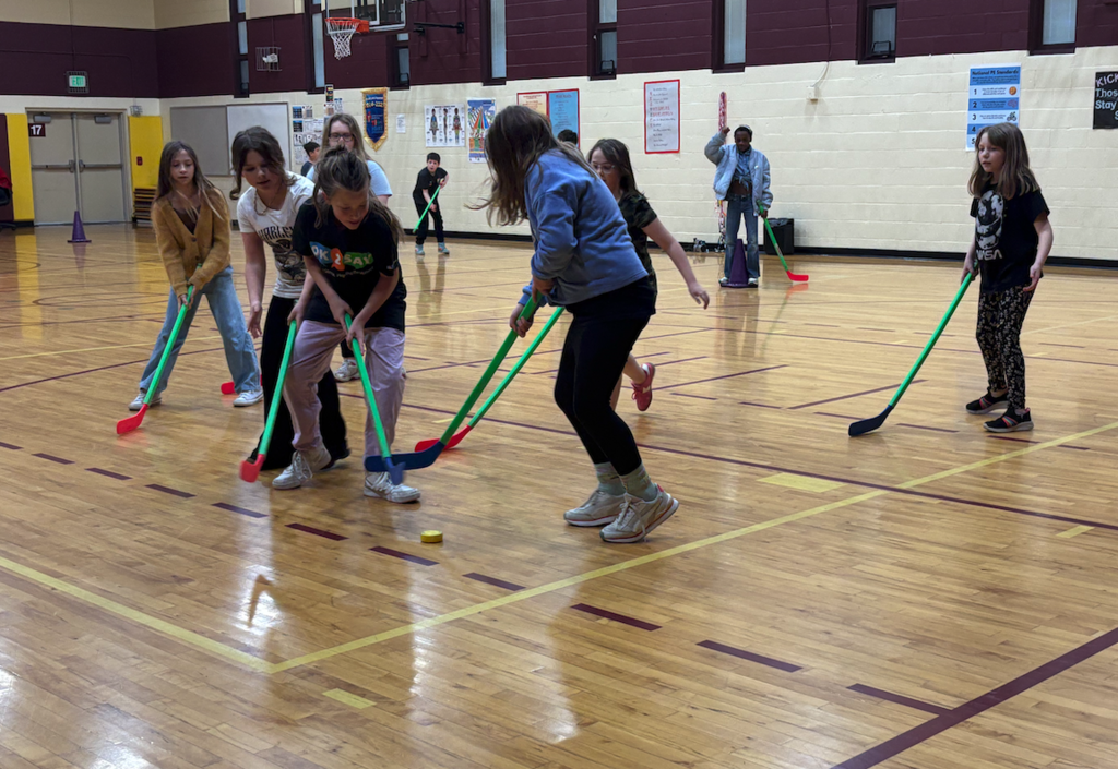 group of kids playing floor hockey