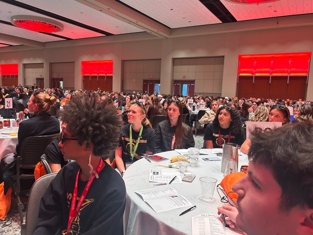 students sitting at tables at conference