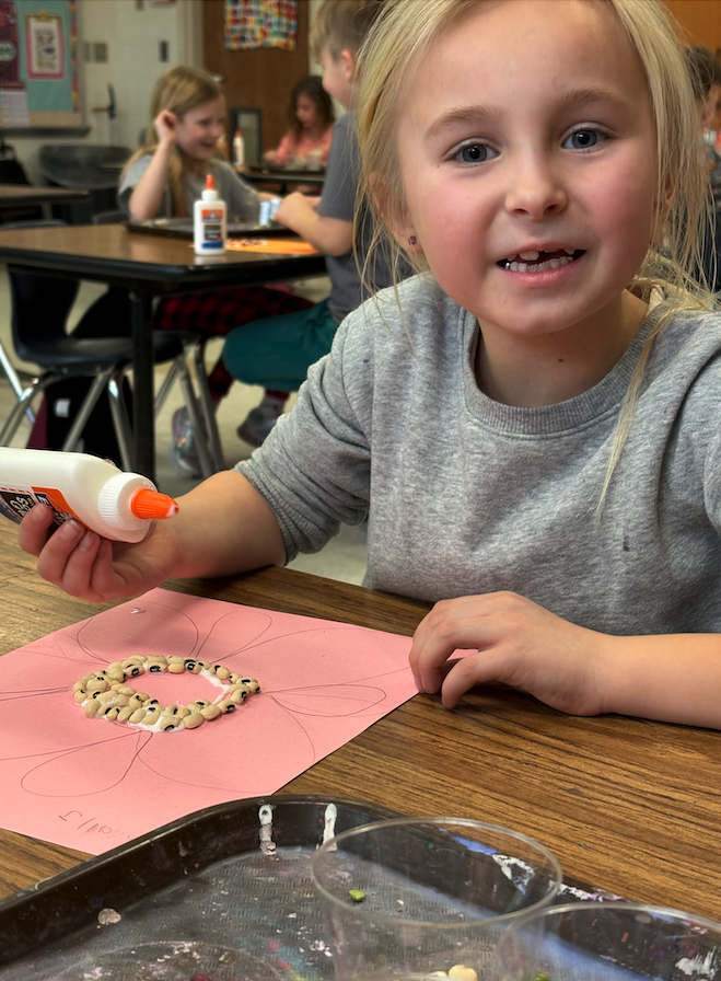 young girl working on bean art
