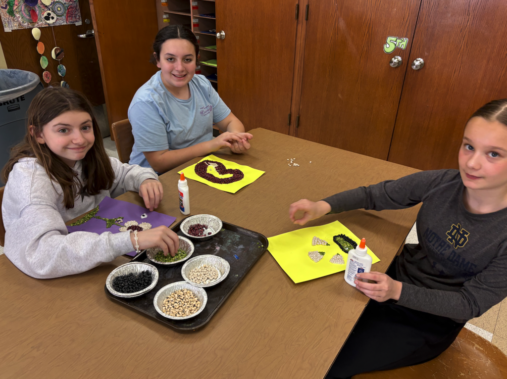 three girls working on bean art