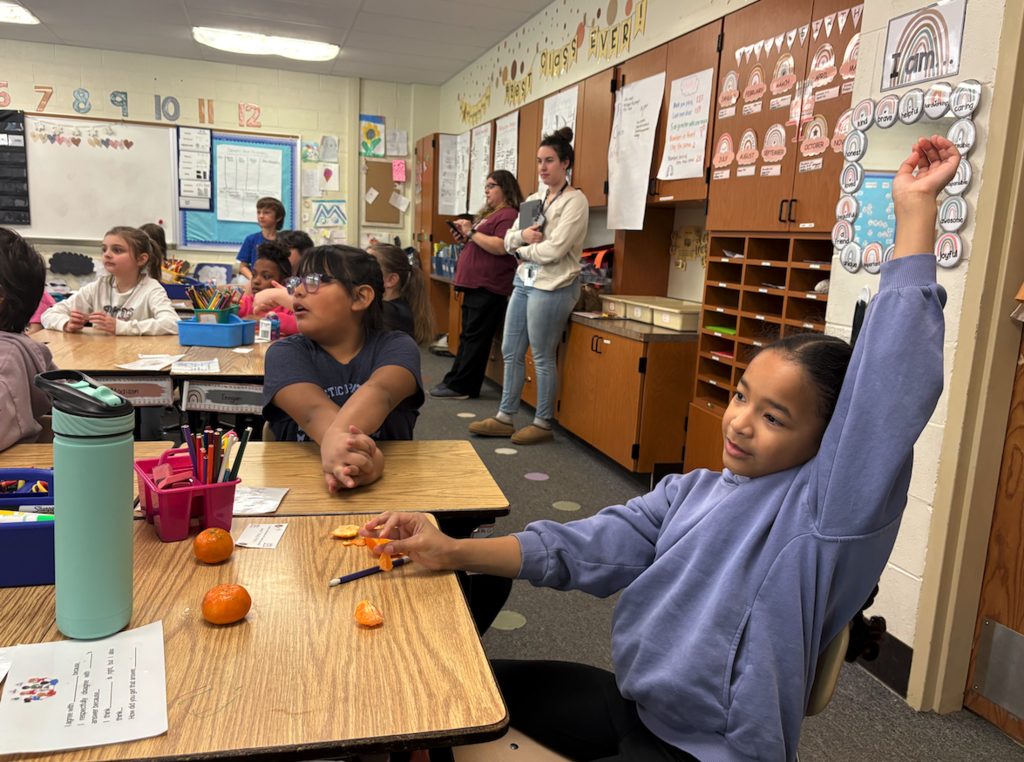 little girl raising her hand
