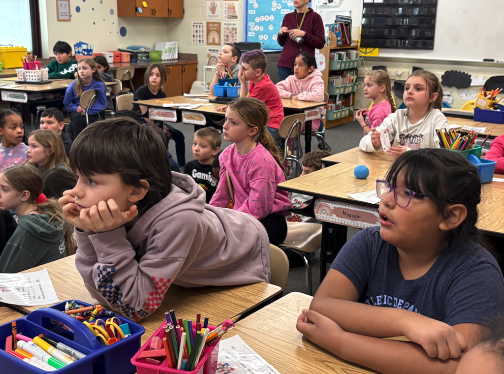 two kids listening to author read book