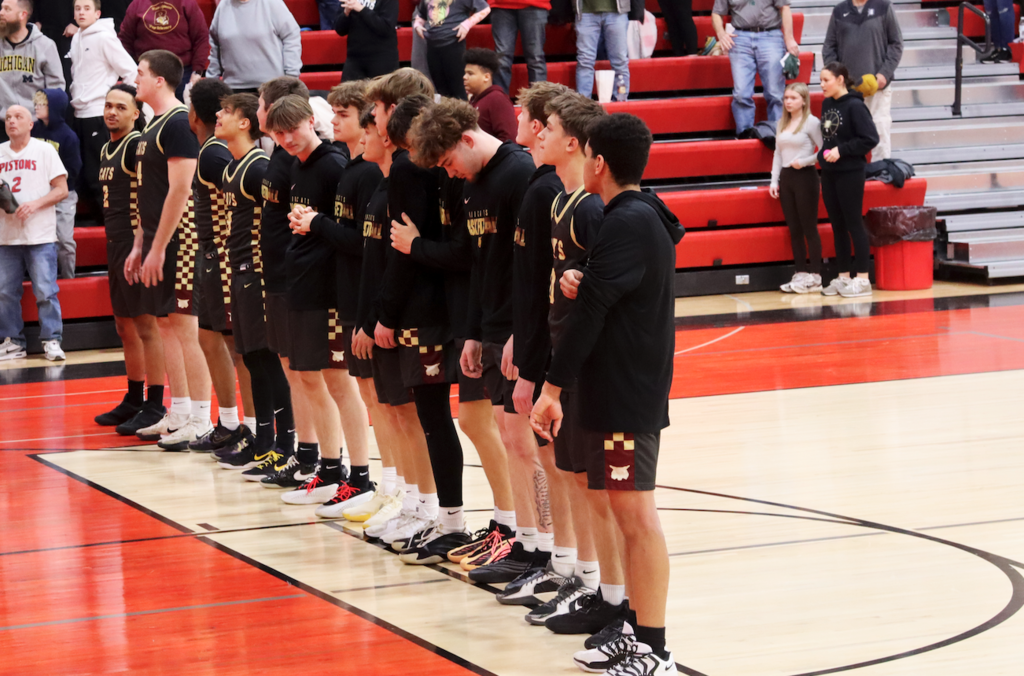 basketball players standing on court doing national anthem