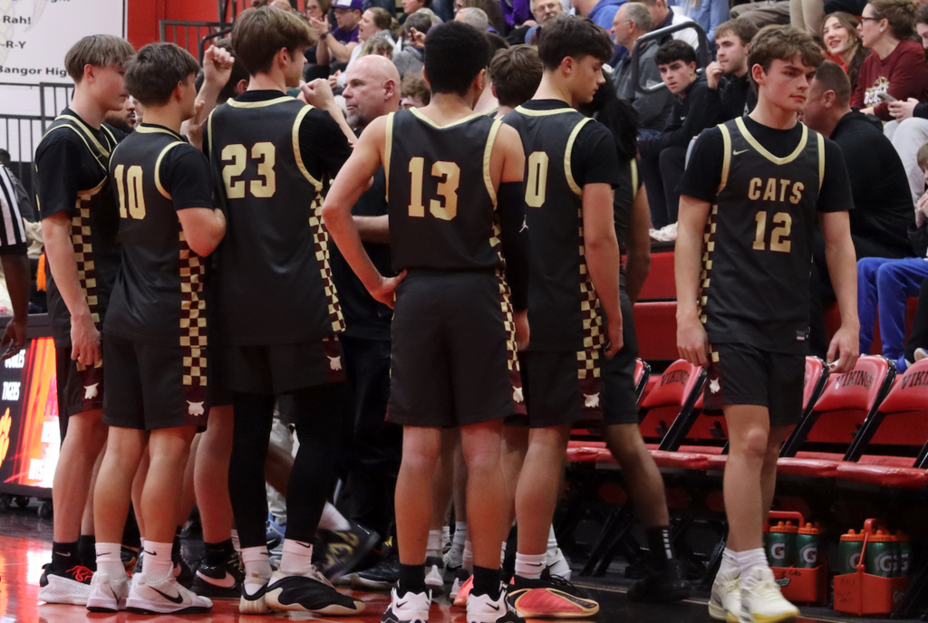 basketball players with coach on sidelines