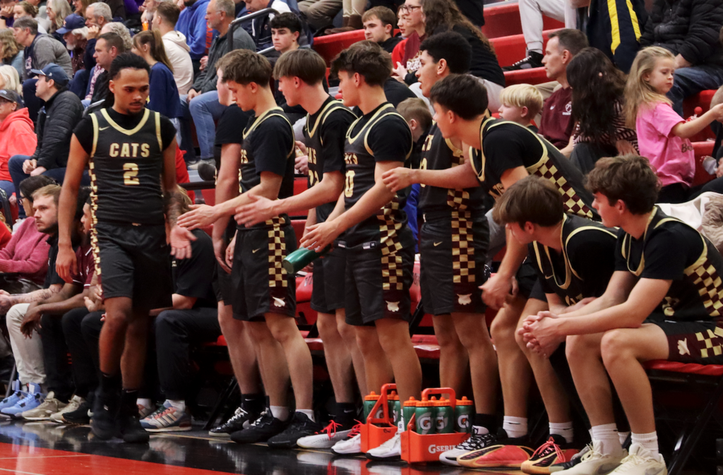 basketball players giving player high five on sideline