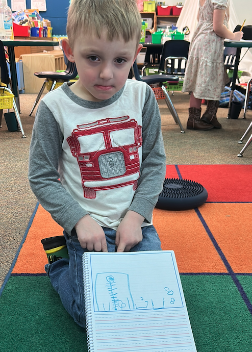 little boy showing notebook