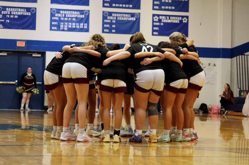 group of basketball players huddled together