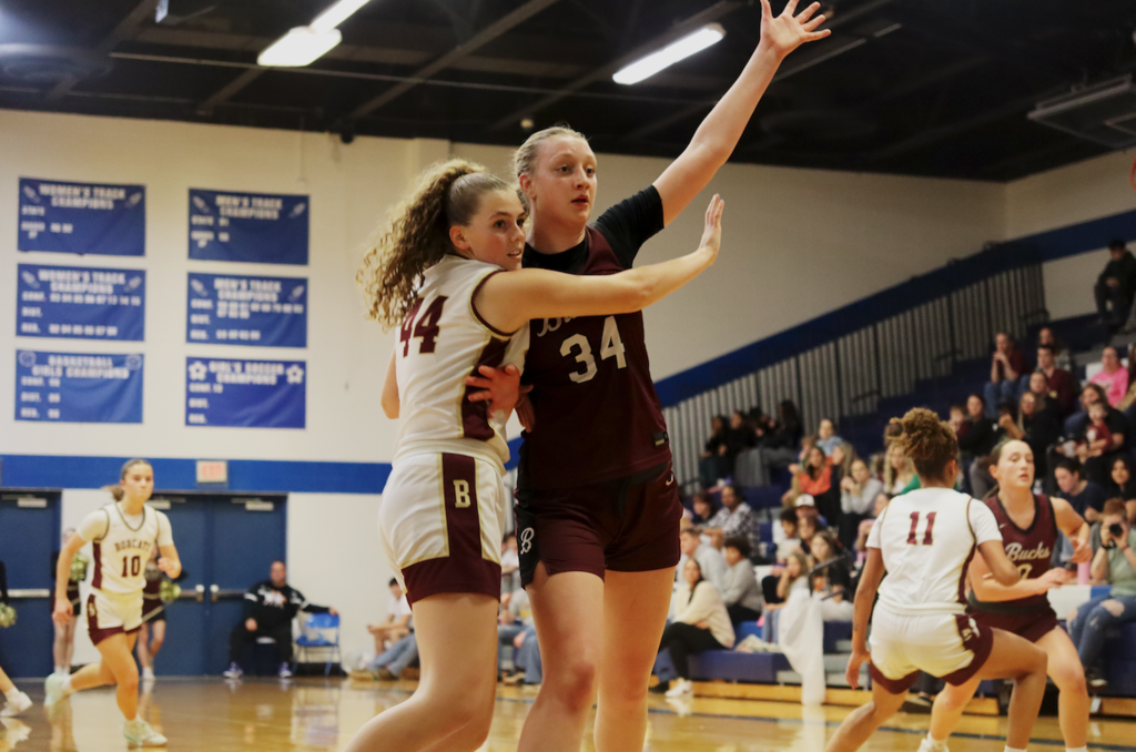 two basketball players blocking each other