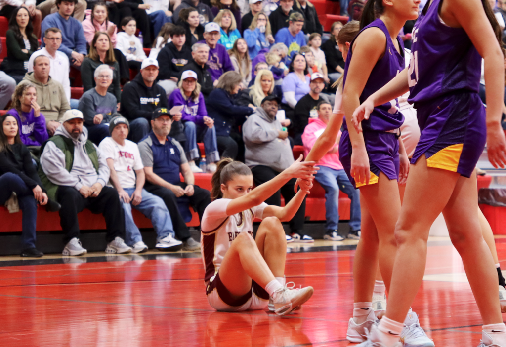 girl getting up from floor of court
