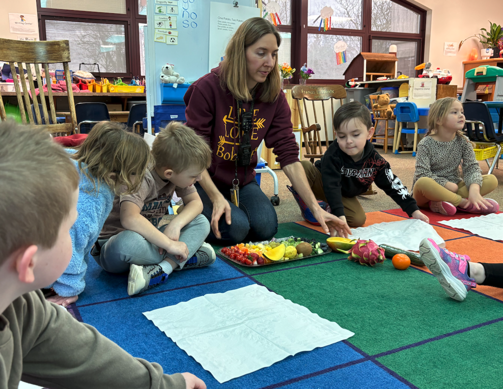 teacher with kids serving fruits and veggies