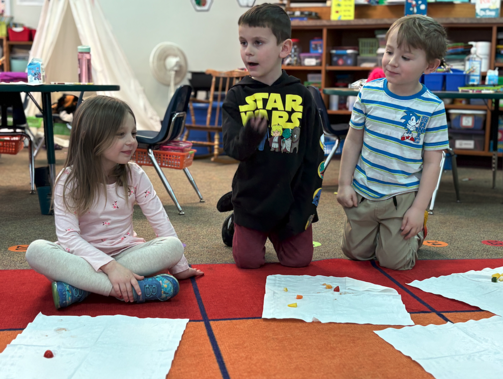 two little boys and a little girl trying veggies
