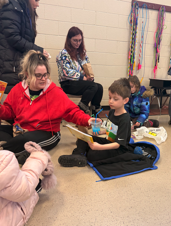 parent with little boy holding a book