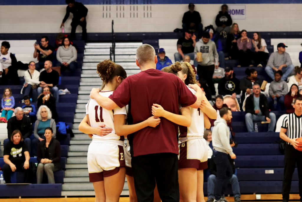 girls and coach huddled