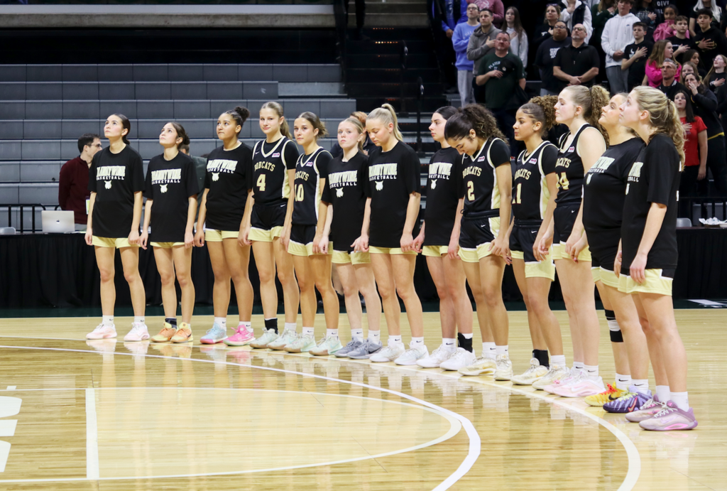 team standing on court for national anthem