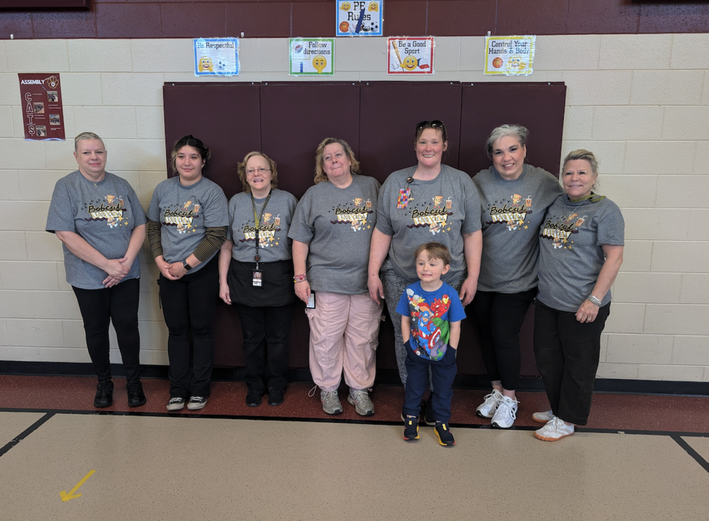 group of food service workers with little boy