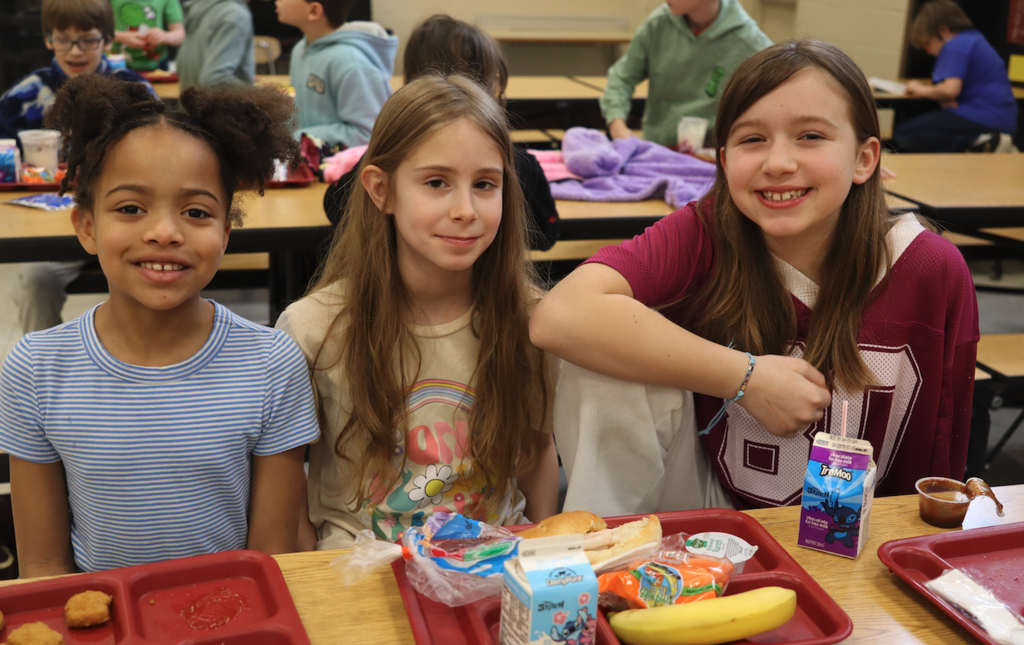 three girls sitting together at lunch