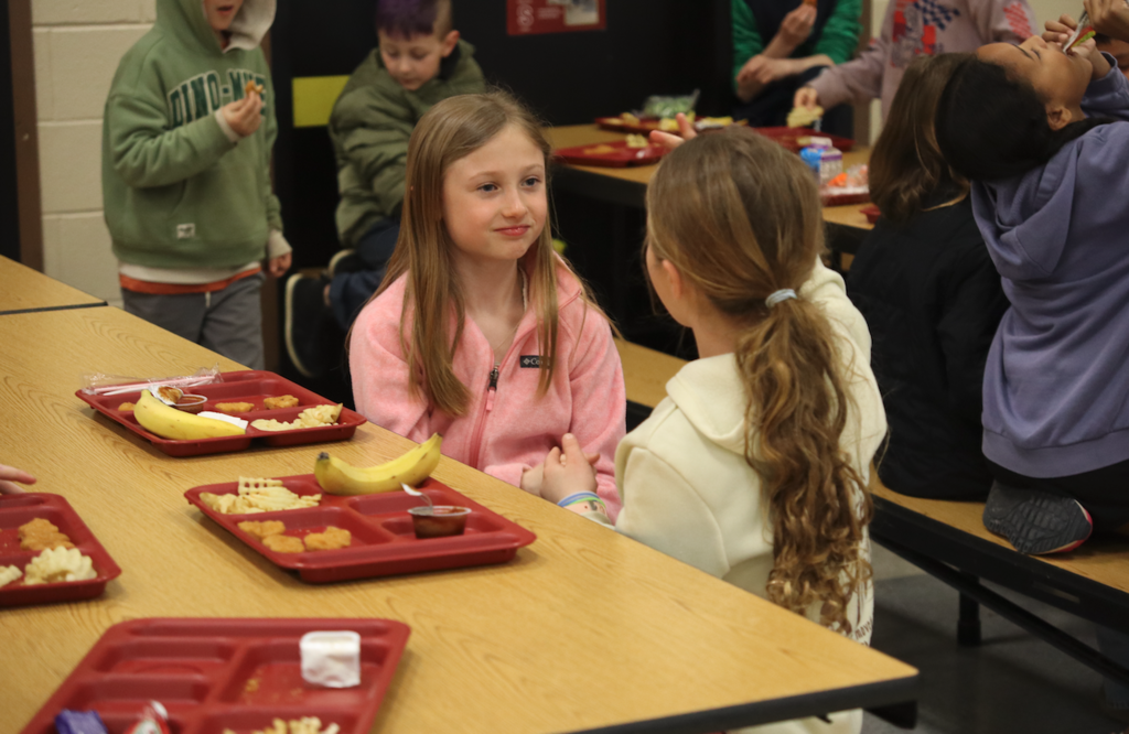 two girls sitting together at lunch