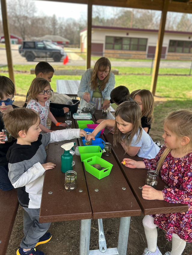 students at picnic table making terrariums