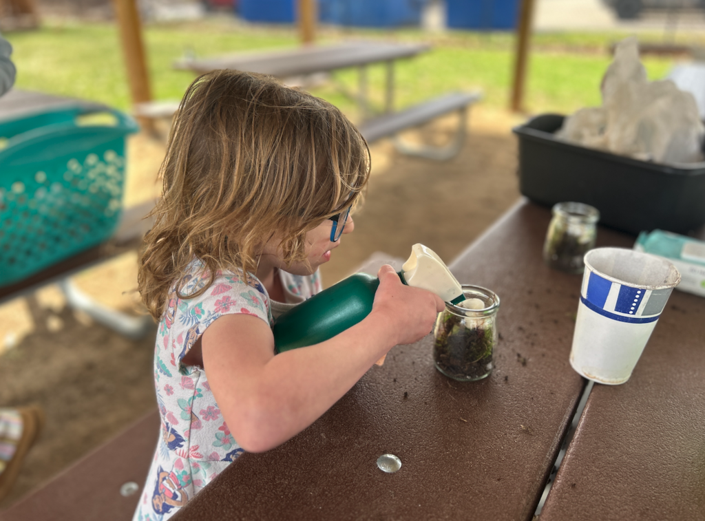 little girl spraying terrarium