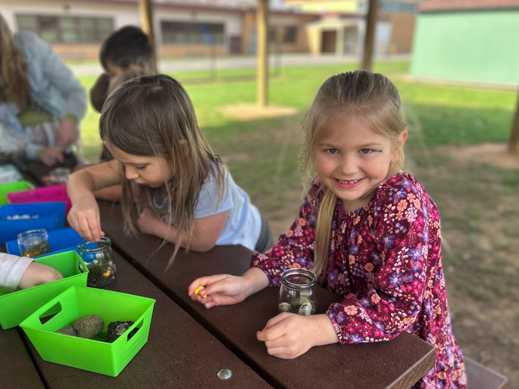 little girl at table making terrarium
