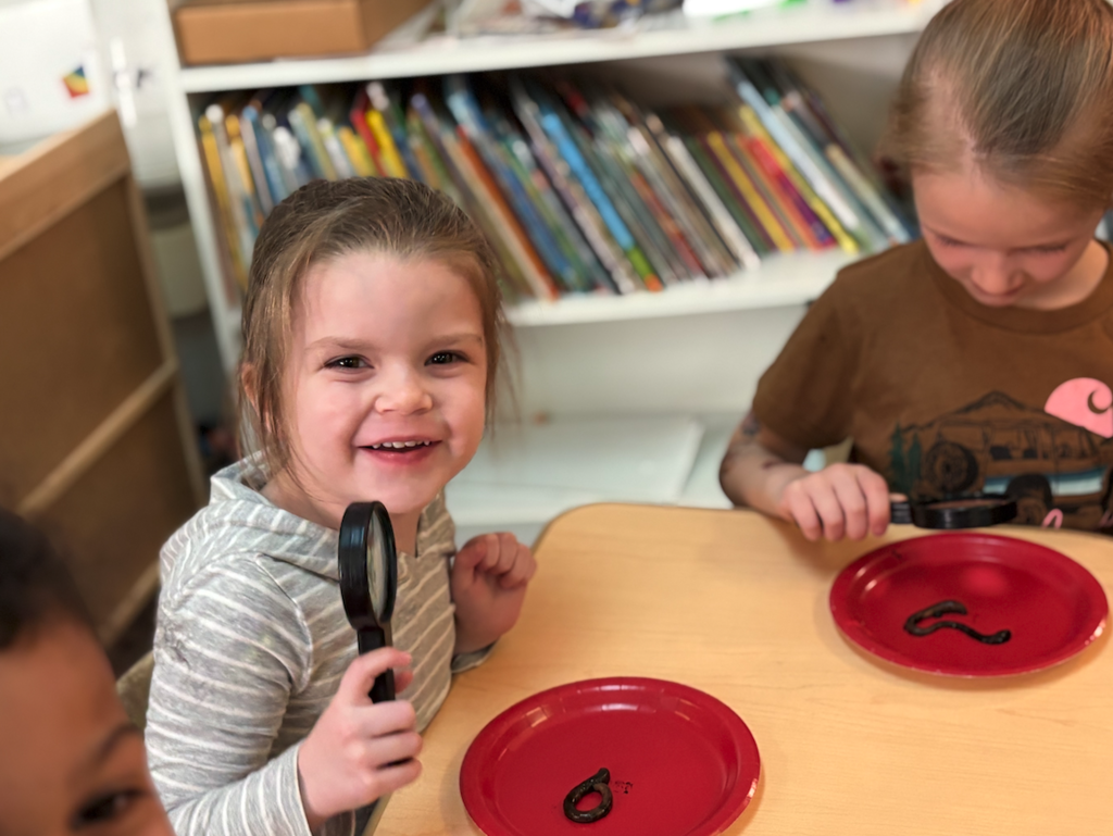 little girl looking at worm