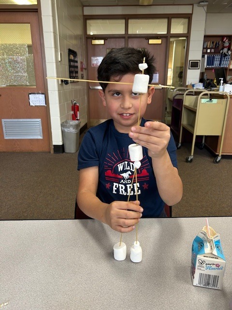 boy working with marshmallow tower