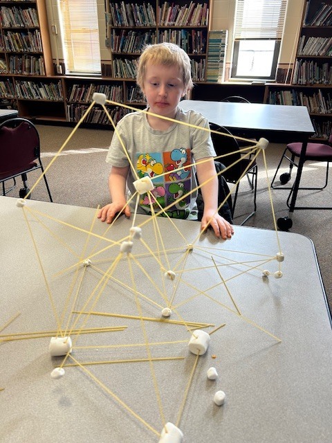 boy working with marshmallow tower