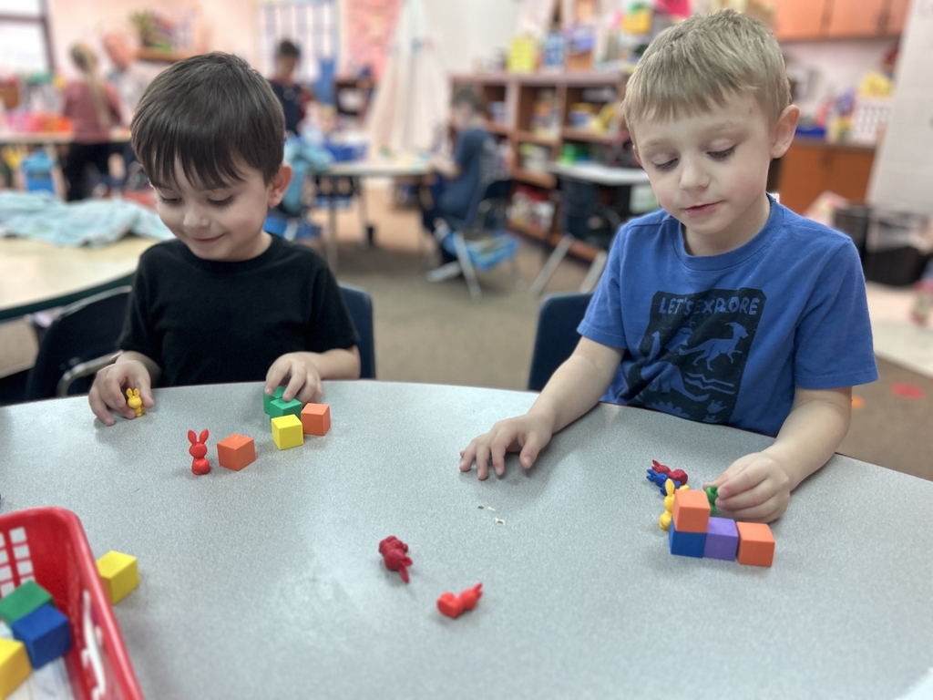 two young boys playing at a table with blocks