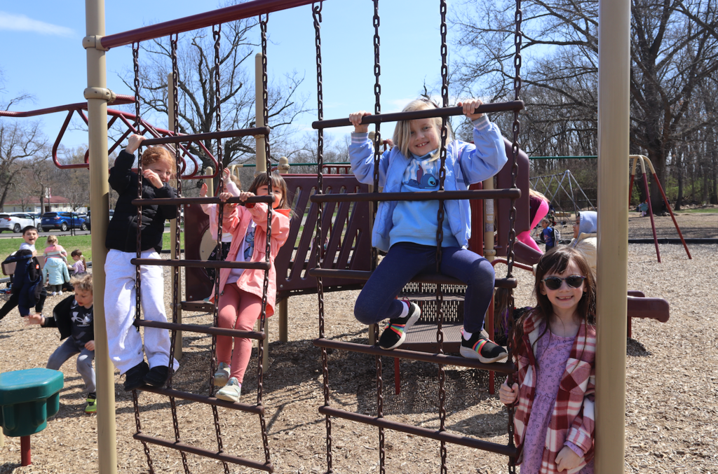 four little girls climbing playground equipment