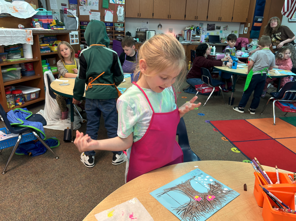 little girl looking at her painting of the season
