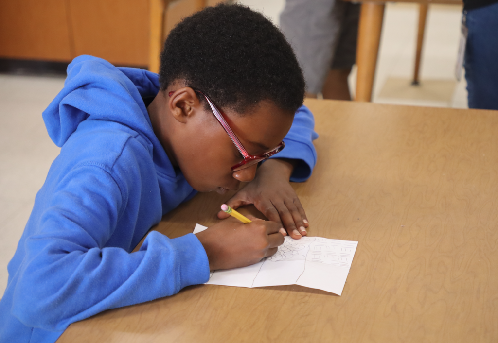 young girl drawing on paper with pencil