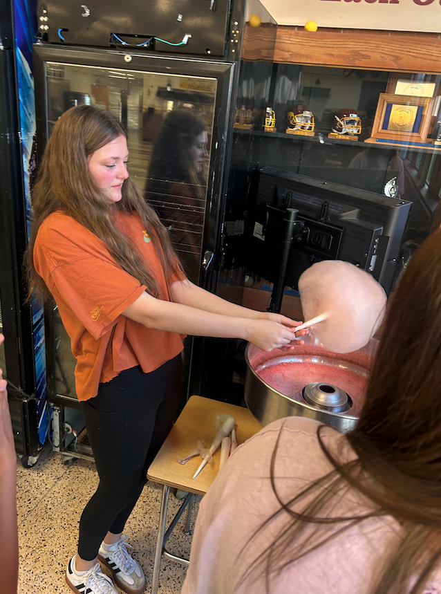 middle school aged girl making cotton candy in the cafeteria