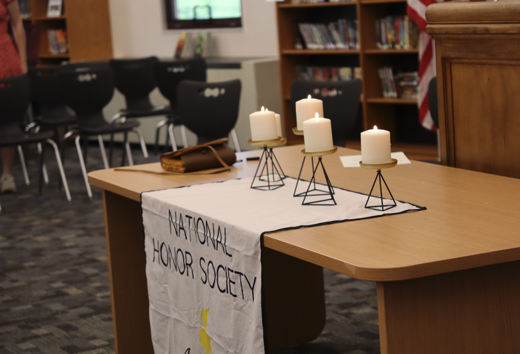 candles sitting on table with national honor society banner