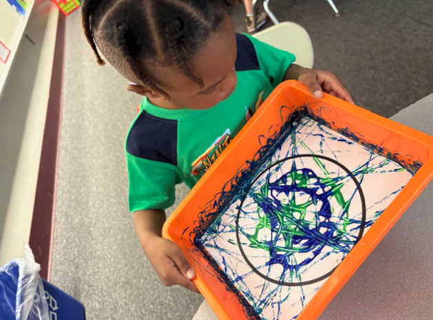 student holding art project