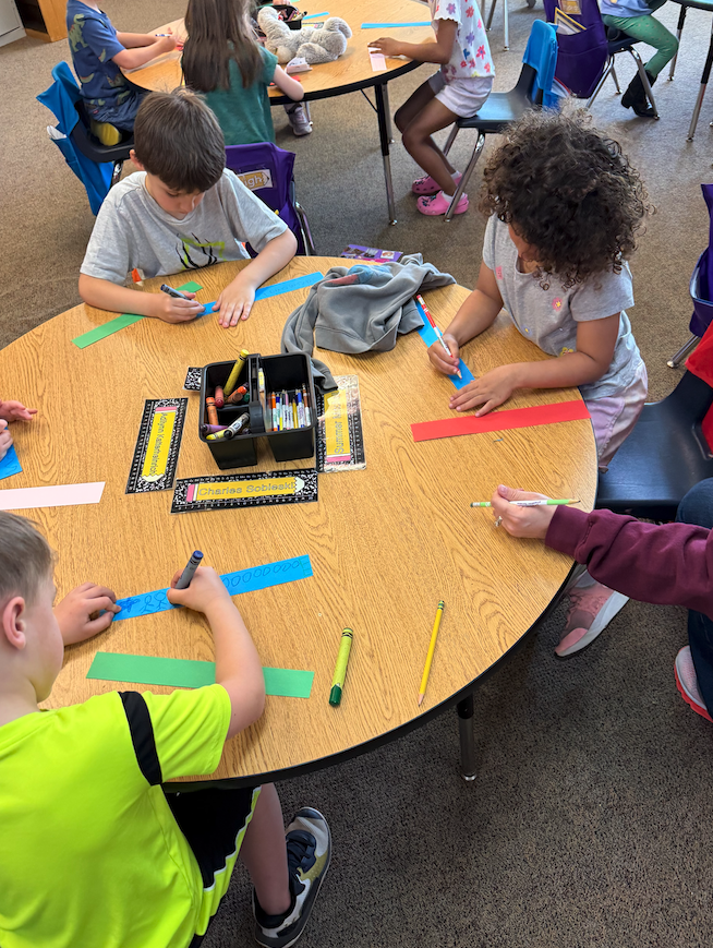 group of kids at table making paper chains