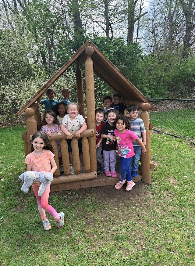 group of DK kids standing in wooden house on playground