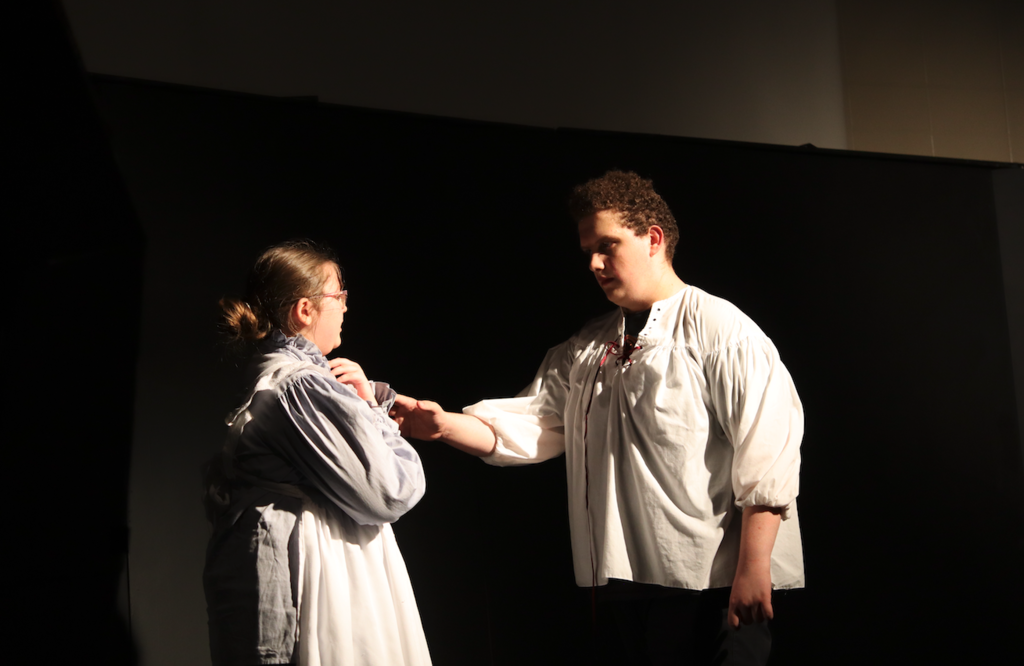an actor putting his hand towards actress on stage