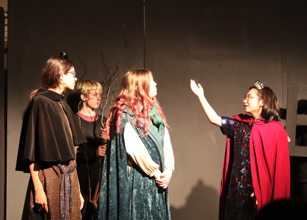 three actresses dressed as witches on stage