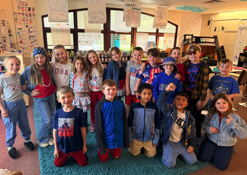 group of kids in classroom dressed in red, white and blue
