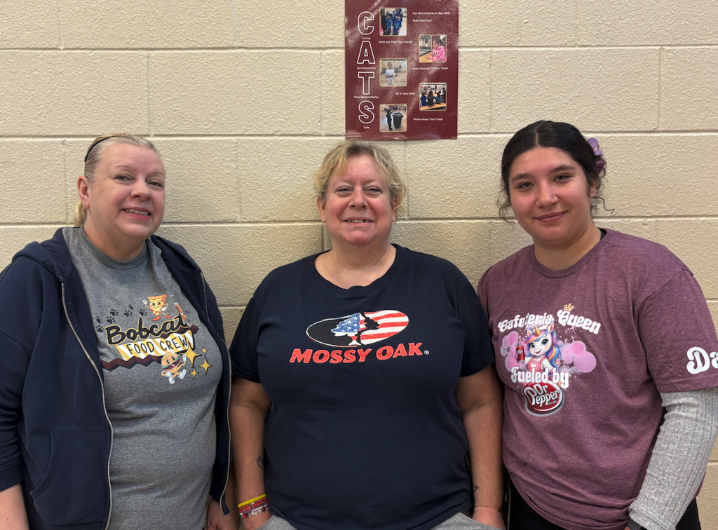 three lunch ladies standing in cafeteria