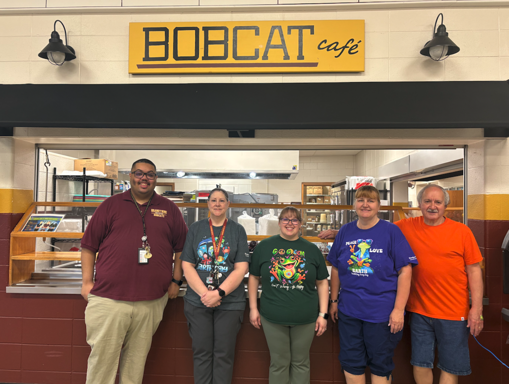 five lunch service people standing in cafeteria