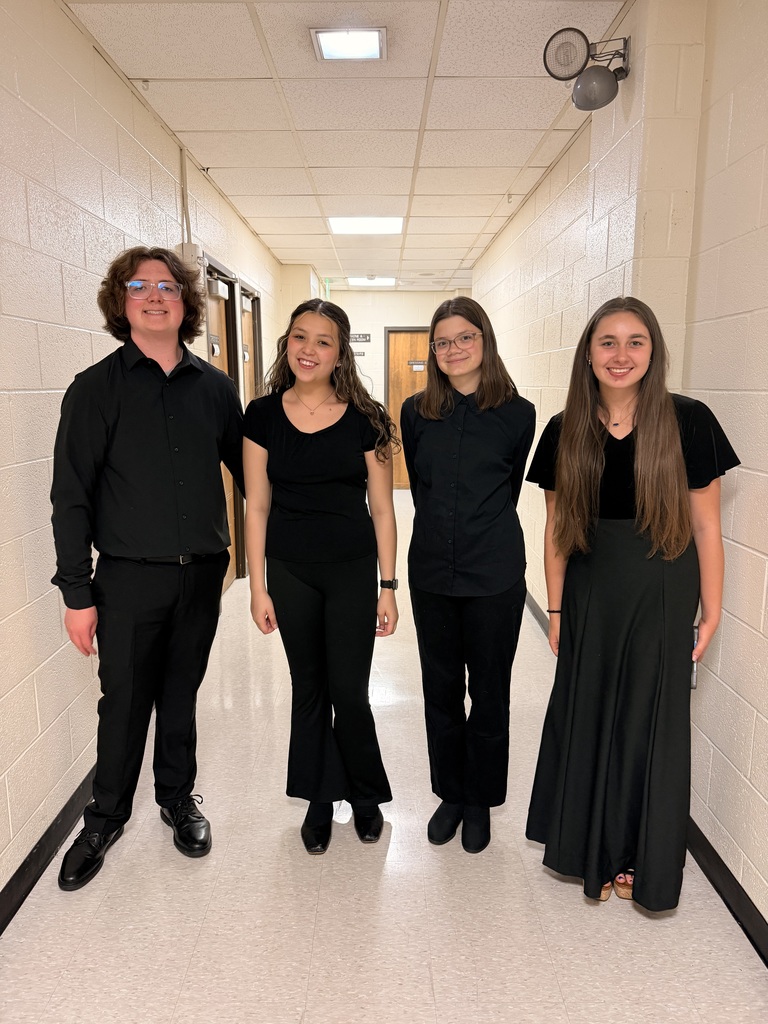 four students dressed in black concert attire 