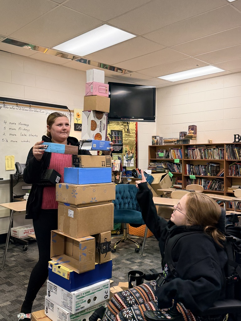 student stacking boxes on top of each other