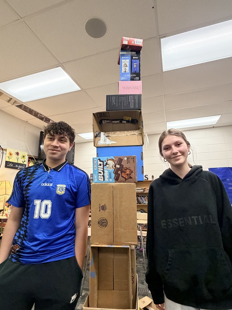 student standing next to box tower
